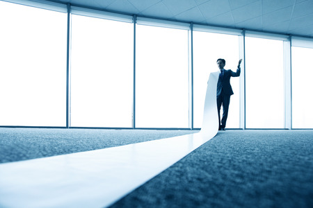 businessman reading long white sheetの写真素材