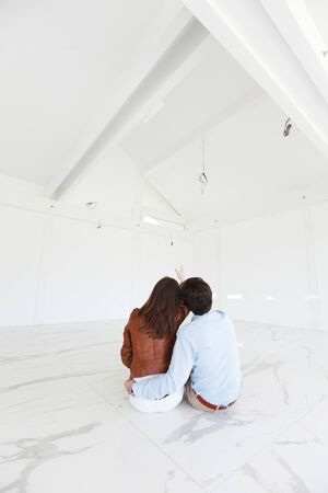 young couple sitting in a new houseの写真素材