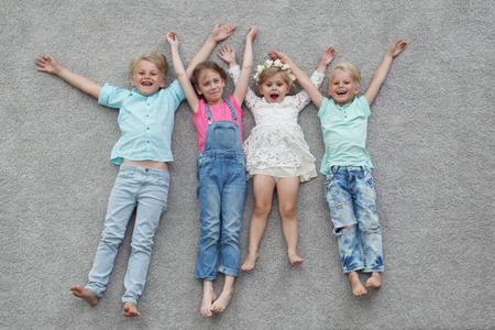 happy kids lying on the floor at homeの写真素材