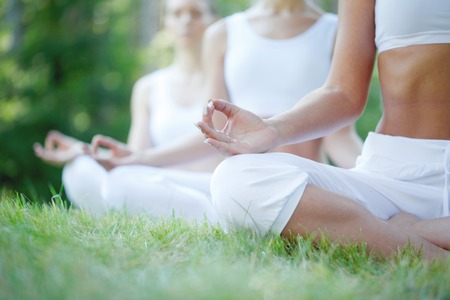 group of women doing yoga at parkの写真素材