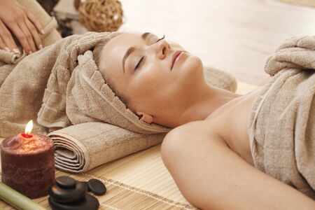 Beautiful young woman relaxing in spa salonの写真素材