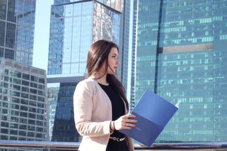 Young beautiful businesswoman outdoors at skyscraper backgroundの写真素材