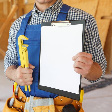 Close-up view of workman with wrench and contractの写真素材