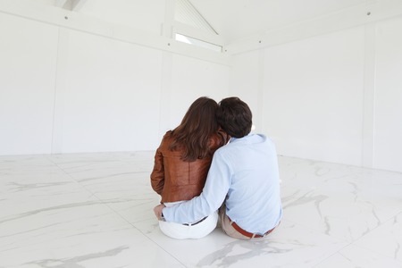 Couple sitting at their new empty apartmentの写真素材