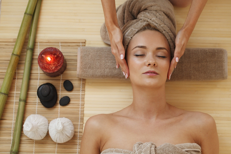 Beautiful young woman relaxing in spa salonの写真素材