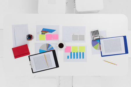 Top view of working table with financial reports, calculator, pencils etcの写真素材