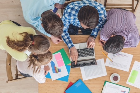 Diverse people working with financial reports and laptopの写真素材