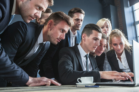 Group of business people using laptop together in office, teamwork conceptの写真素材