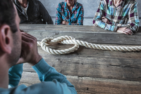 People sitting around the table with rope node on it, business problem conceptの写真素材