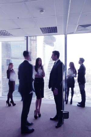 Business people talking in a conference room with city skylineの写真素材