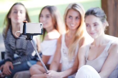 Young beautiful female friends taking selfie outdoorsの写真素材