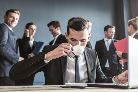 Business man using laptop in office, business team on backgroundの写真素材