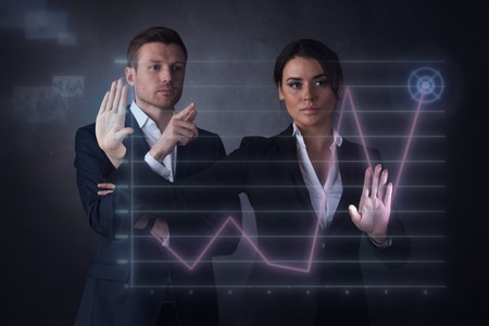 Business people touching a graph indicating growth on virtual displayの写真素材