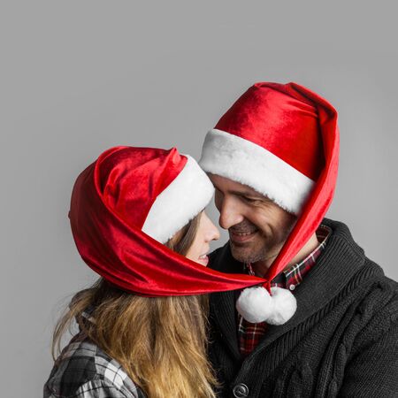 Happy smiling couple in Santa's hats bound togetherの写真素材