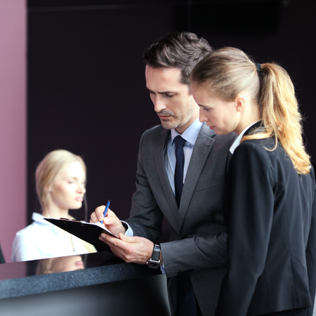Business people filling forms at reception front deskの写真素材