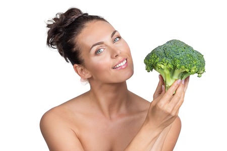 Portrait of a beautiful woman with perfect skin holding broccoli, isolated on white backgroundの写真素材