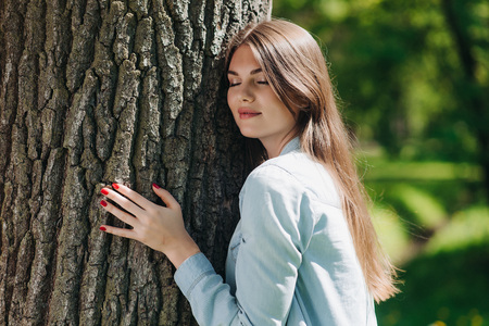 Young woman hugging a big tree, love nature conceptの写真素材