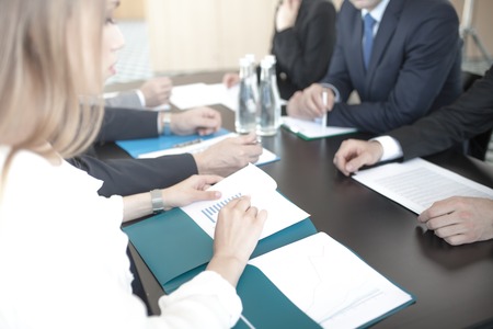 Business people discussing documents at workplace in office sitting around the tableの写真素材