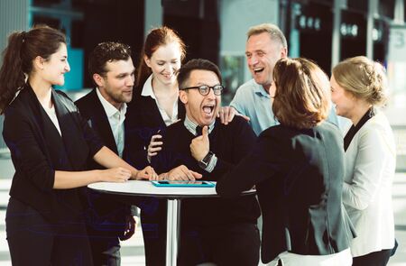 Group of happy business people congratulating their successful coworkerの写真素材