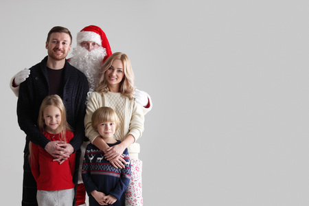Portrait of young family with two children with Santa Claus, gray background with copy space for textの写真素材