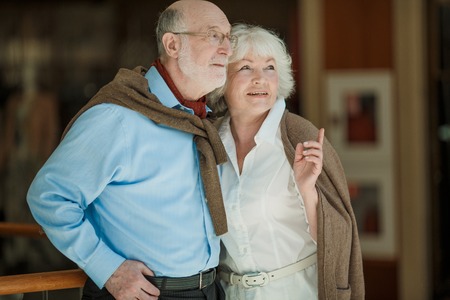 Portrait of senior couple looking together aside and embracingの写真素材