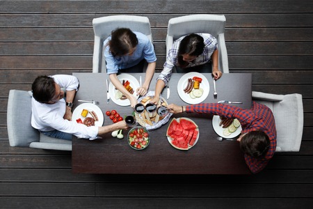 Four friends having dinner, top viewの写真素材
