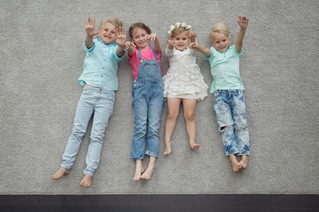 Group of happy kids laying on floor, top viewの写真素材