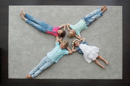 Group of happy kids laying on floor, top viewの写真素材