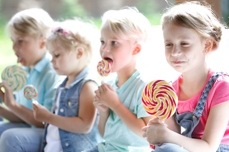 Group of happy smiling children with lollipops outdoorsの写真素材