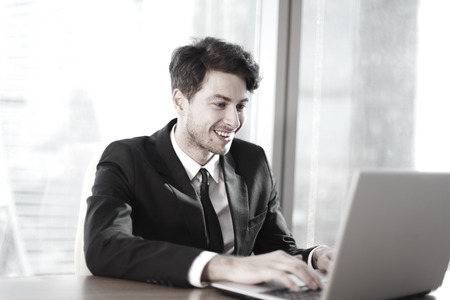 Busy businessman in office working on his laptop.の写真素材