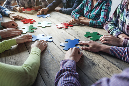 Business people and puzzle on wooden table, teamwork conceptの写真素材