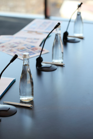 Conference room table for business meeting with microphones and bottles of waterの写真素材