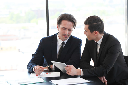 Business people using tablet pc together at officeの写真素材