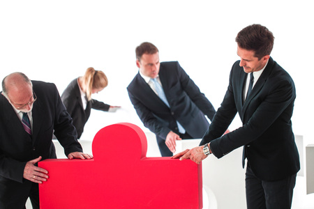 Business teamwork and problem solution concept . Business people with giant puzzle pieces . Partnership and collaboration , studio isolated on white backgroundの写真素材
