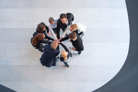 High angle view of a team of united businesspeople standing with their hands together in a huddle in...