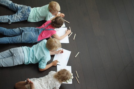 Group of cute children drawing with colorful pencils on floor