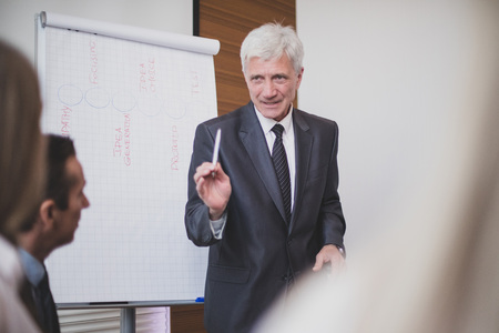 Business man speaking on seminar , whiteboard or flipchart on backgroundの写真素材