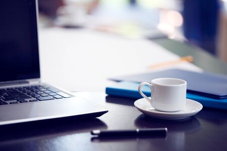 Office workplace with laptop coffee and office suppliesの写真素材