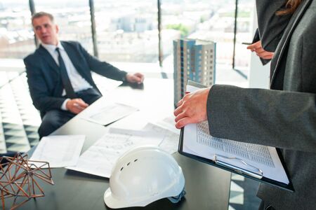Meeting of architects and business investors, model of modern multi storey residential building...