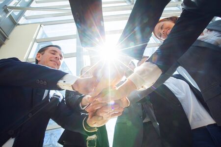 Business teamwork concept, coworkers putting hands together in a tower stacking hands unity...