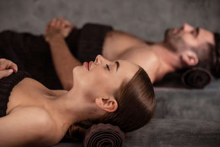 Beautiful couple relaxing together at spa center at beauty treatment massageの写真素材