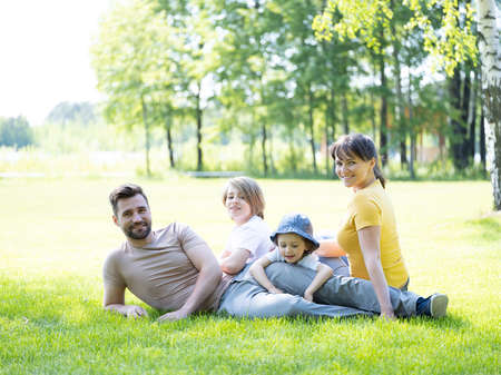 Portrait of happy family enjoying in park on sunny a dayの写真素材