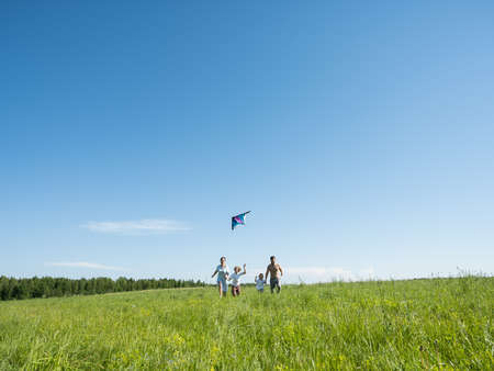 Family Flying Kite Together Outdoors in summer meadow love parenting Conceptの写真素材