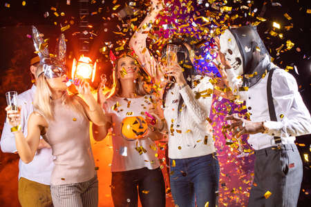 Happy people men and women mixed race dancing together on Halloween party