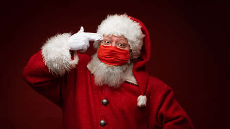 Santa Claus committing suicide with imaginary gun tired of wearing protective mask. Christmas with social distance. Covid-19の写真素材