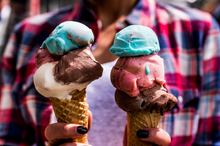 Girl Holding ice cream in the cone. Summer Concept.