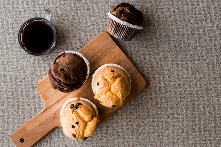 Chocolate and Vanilla Muffins with coffee on wooden surface. bakery concept.の写真素材