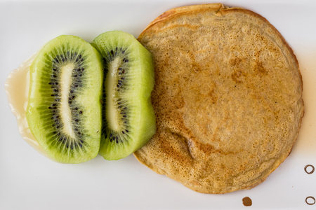 Pancake with kiwi and maple syrup (made with organic flour) homemade product.の写真素材