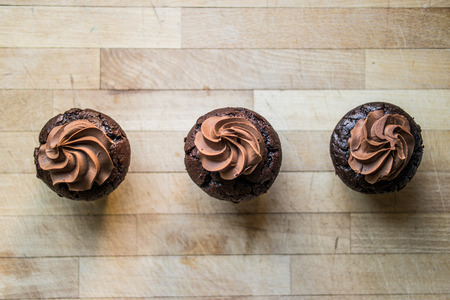 Chocolate cupcakes on wooden surface.の写真素材