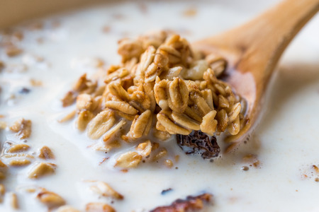 Granola with milk in a spoon. Breakfast Concept.